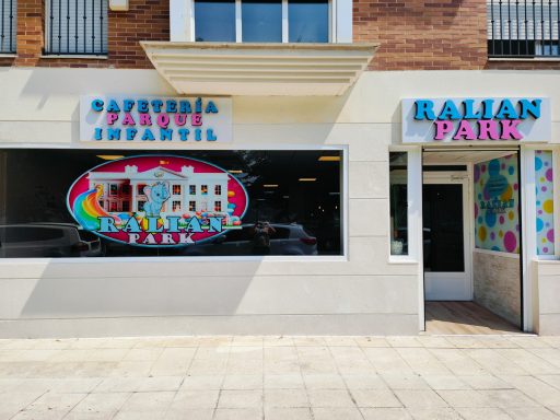 Carteles de "Pandi Infantil" y "Ralian Park" en un edificio comercial.